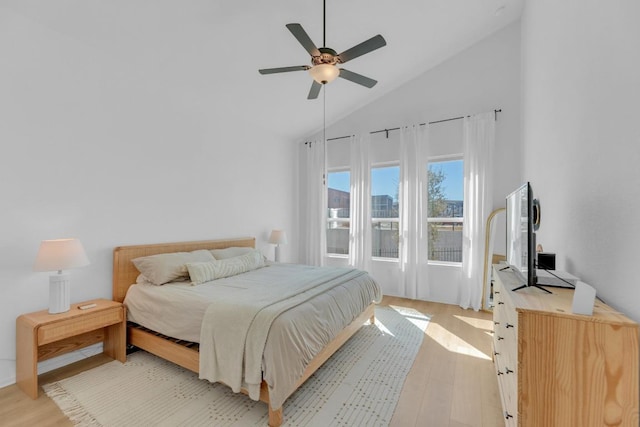 bedroom with light wood-style flooring, high vaulted ceiling, and ceiling fan