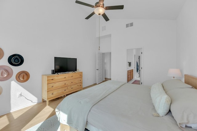 bedroom featuring visible vents, connected bathroom, ceiling fan, wood finished floors, and high vaulted ceiling