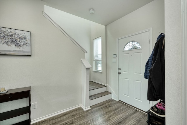 foyer with stairs, wood finished floors, and baseboards