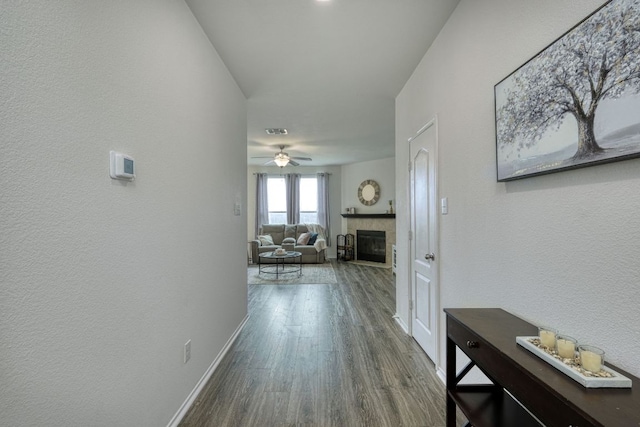 13505 Abraham Lincoln St, Manor, TX 78653 - corridor featuring dark wood-style floors, a textured wall, and baseboards