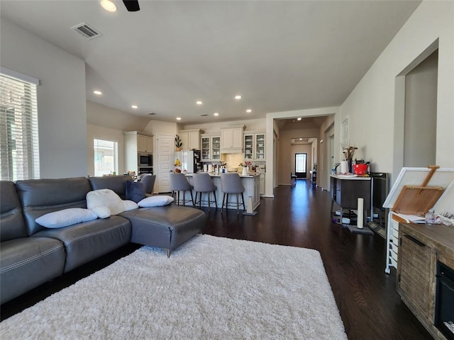 living area featuring recessed lighting, visible vents, and dark wood-style flooring