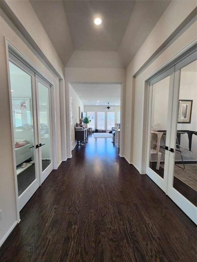 corridor with wood finished floors, french doors, baseboards, and a tray ceiling