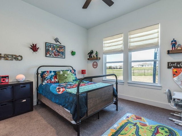 carpeted bedroom with ceiling fan and baseboards