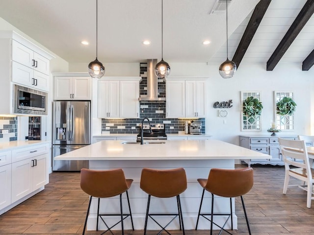 kitchen featuring decorative backsplash, appliances with stainless steel finishes, a breakfast bar, and a sink