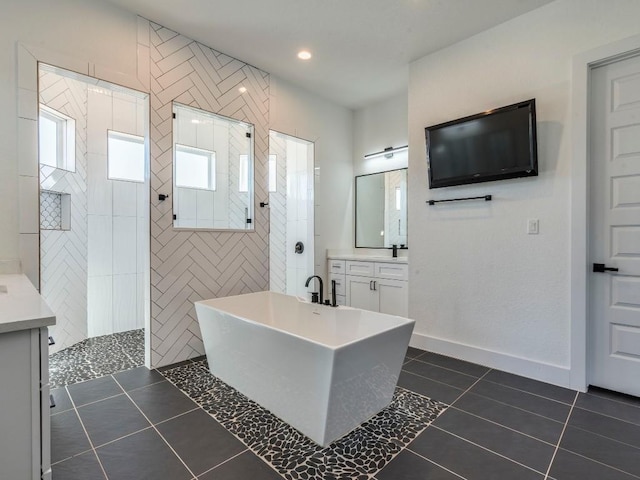 full bathroom with a wealth of natural light, tile patterned flooring, a freestanding bath, and a walk in shower