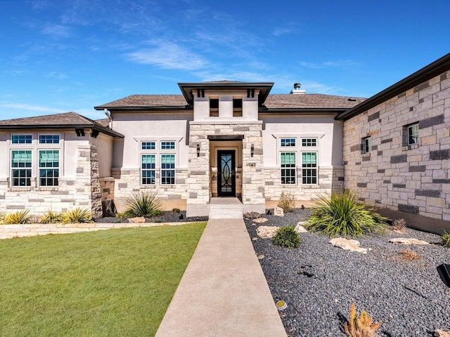 prairie-style home with stone siding, a front lawn, and stucco siding