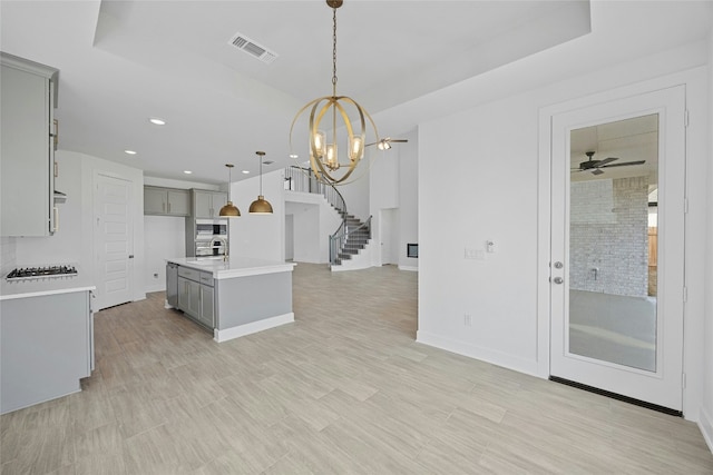 216 Echo Pass, Liberty Hill, TX 78642 - kitchen with gray cabinetry, stainless steel appliances, light countertops, decorative light fixtures, and recessed lighting