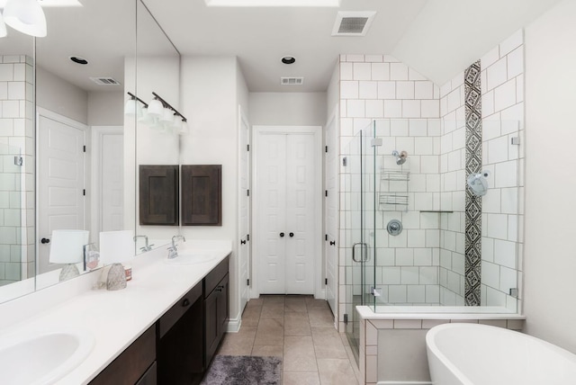 full bathroom featuring tile patterned flooring, a sink, visible vents, a soaking tub, and a stall shower