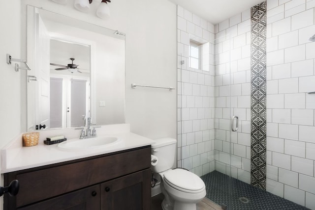 bathroom with ceiling fan, a shower stall, toilet, and vanity