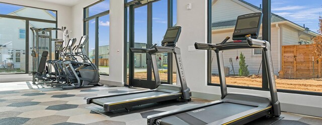 gym featuring carpet and baseboards