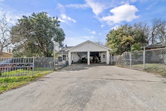 view of side of home featuring driveway, fence, and a gate