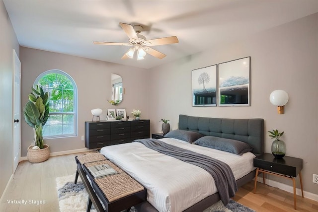 bedroom with light wood-style floors, baseboards, and a ceiling fan