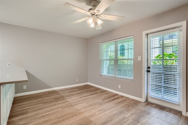 unfurnished room with a ceiling fan, a healthy amount of sunlight, light wood-style flooring, and baseboards