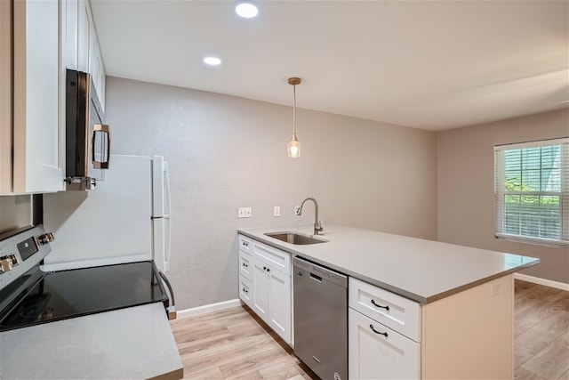 kitchen with stainless steel appliances, a peninsula, a sink, white cabinets, and light wood-type flooring