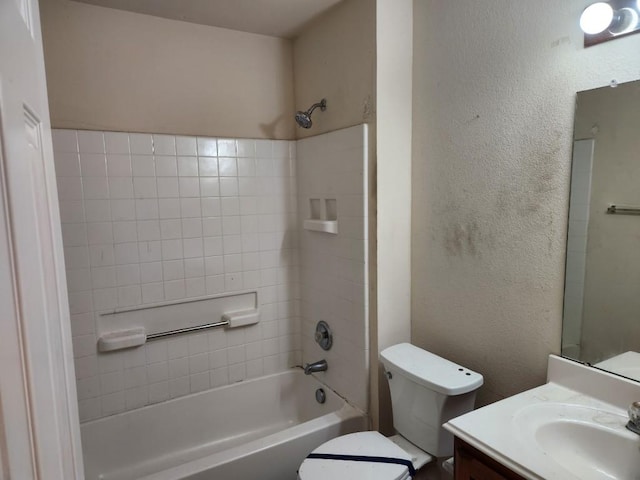 full bathroom featuring a textured wall, bathing tub / shower combination, vanity, and toilet