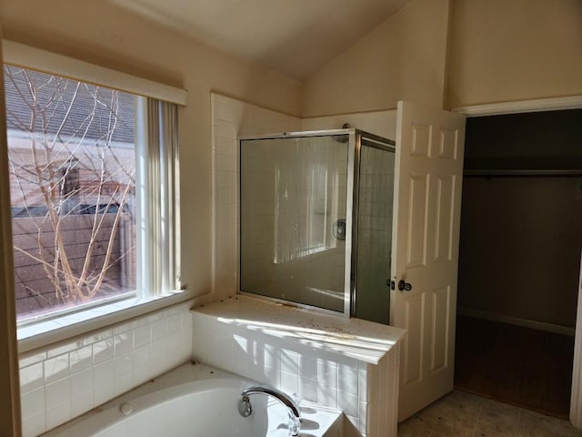 bathroom featuring vaulted ceiling, tile patterned flooring, a shower stall, and a bath