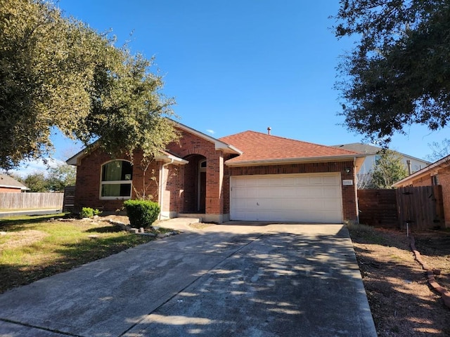 single story home featuring a garage, concrete driveway, brick siding, and fence