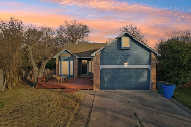 view of front of property with driveway, a wooden deck, fence, and brick siding