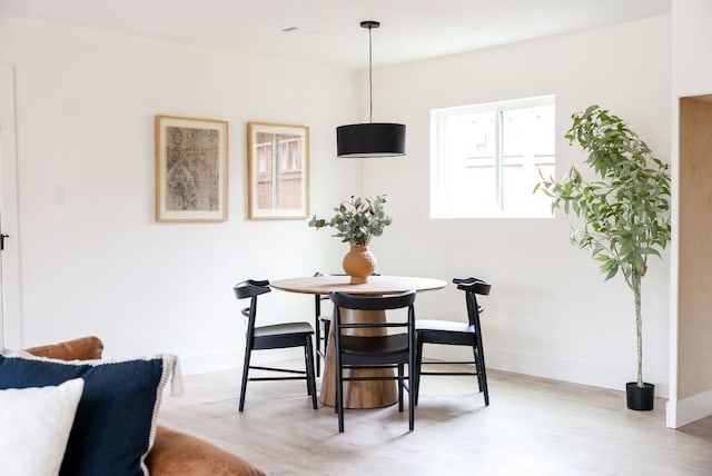 dining room featuring light wood-type flooring and baseboards