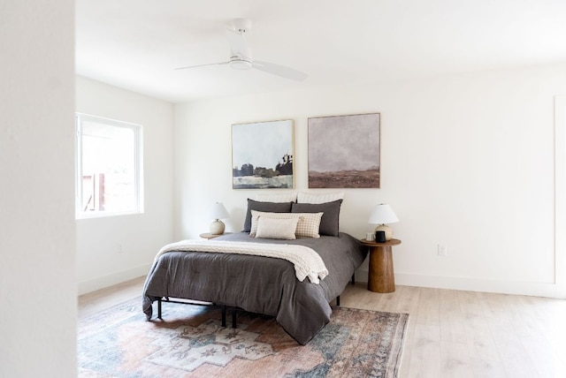 bedroom with a ceiling fan, baseboards, and wood finished floors