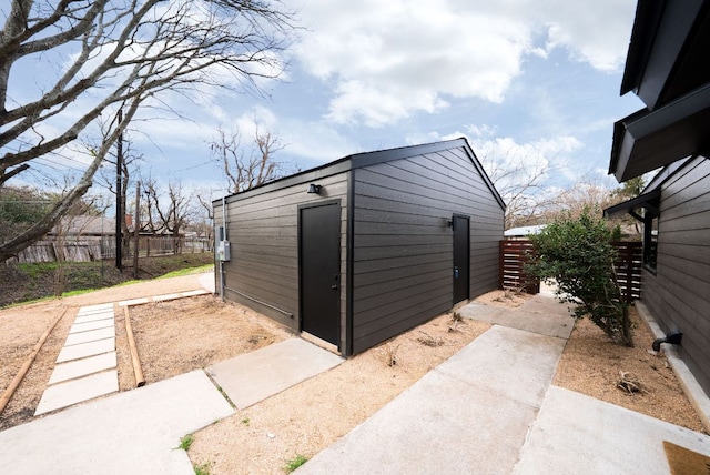 view of outbuilding with fence and an outdoor structure