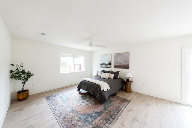 bedroom featuring baseboards, visible vents, ceiling fan, and wood finished floors