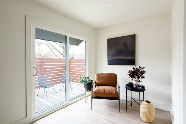 sitting room with baseboards and wood finished floors