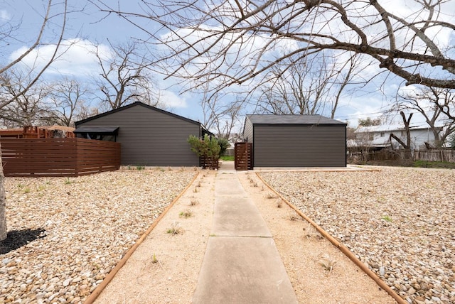 exterior space with a storage unit, an outdoor structure, and fence