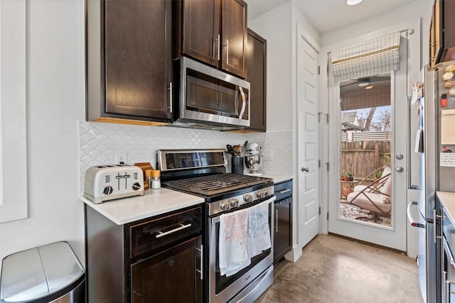 kitchen with dark brown cabinetry, concrete floors, light countertops, appliances with stainless steel finishes, and decorative backsplash