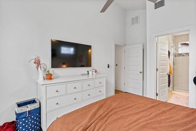 bedroom featuring high vaulted ceiling, visible vents, and ensuite bathroom