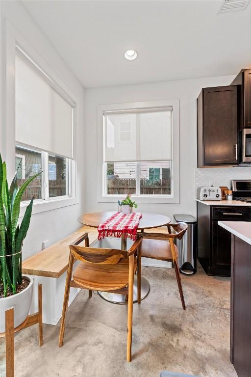 dining area with concrete floors, breakfast area, visible vents, and recessed lighting