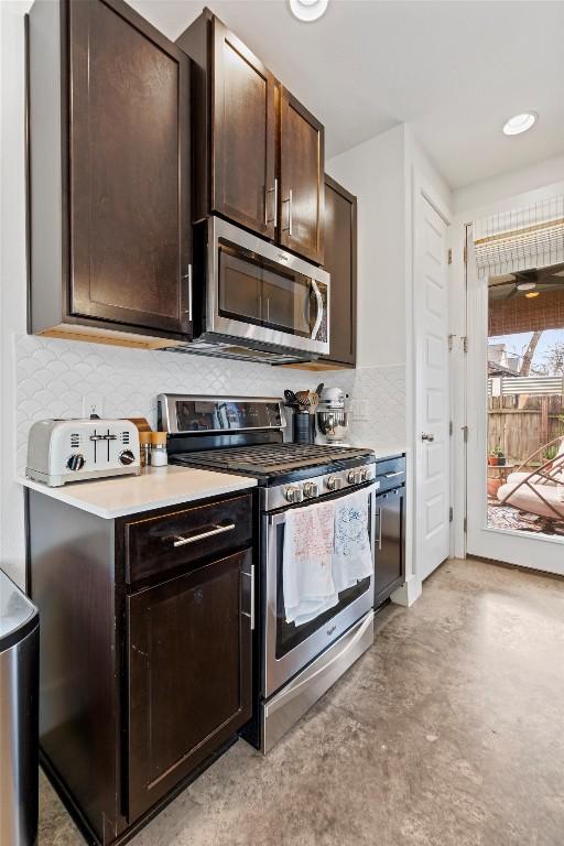 kitchen featuring stainless steel appliances, light countertops, dark brown cabinetry, and decorative backsplash