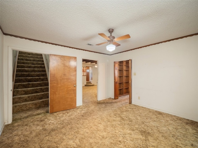 805 Wanta Hideaway, Spicewood, TX 78669 - carpeted spare room with crown molding, stairs, ceiling fan, a textured ceiling, and baseboards