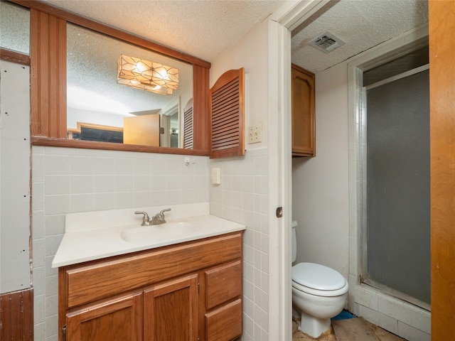 805 Wanta Hideaway, Spicewood, TX 78669 - bathroom with a textured ceiling, vanity, toilet, tile walls, and a shower stall