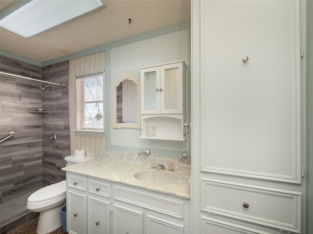 805 Wanta Hideaway, Spicewood, TX 78669 - bathroom with vanity, tiled shower, and toilet