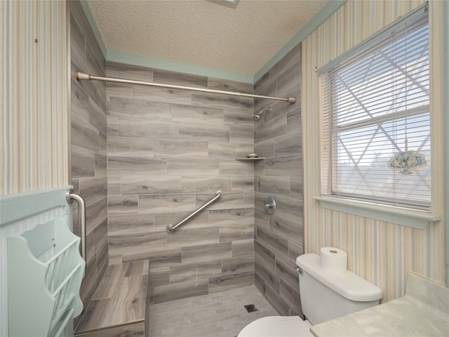 805 Wanta Hideaway, Spicewood, TX 78669 - full bathroom featuring toilet, wallpapered walls, a shower stall, and a textured ceiling
