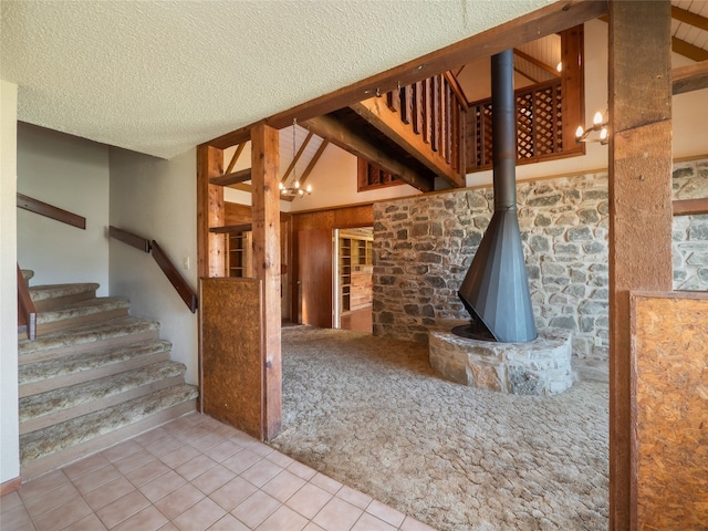 805 Wanta Hideaway, Spicewood, TX 78669 - unfurnished living room featuring stairway, tile patterned flooring, lofted ceiling, a textured ceiling, and carpet