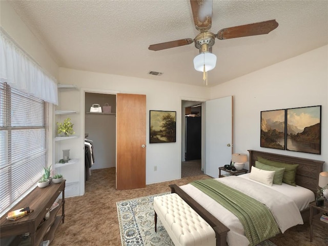 805 Wanta Hideaway, Spicewood, TX 78669 - carpeted bedroom with a textured ceiling, a spacious closet, a closet, and ceiling fan