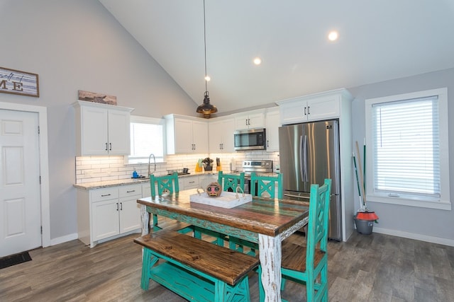 kitchen featuring appliances with stainless steel finishes, dark wood finished floors, white cabinetry, and decorative backsplash