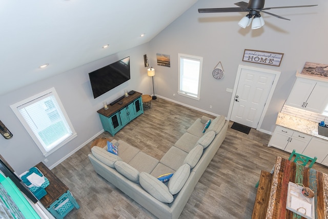 living room with baseboards, high vaulted ceiling, wood finished floors, and recessed lighting