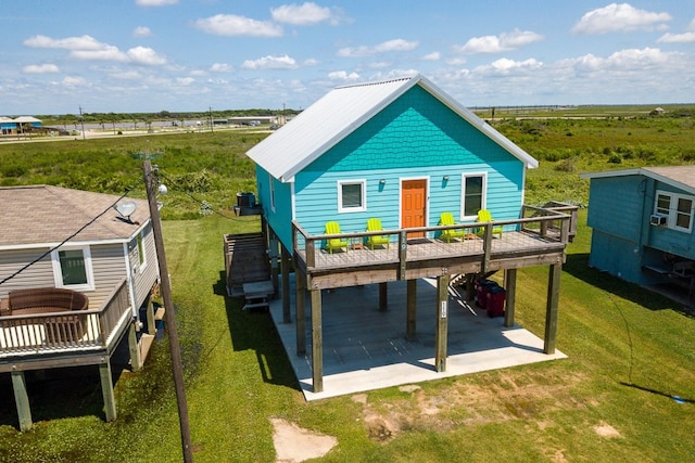 rear view of property featuring a deck, a patio, a yard, and central AC