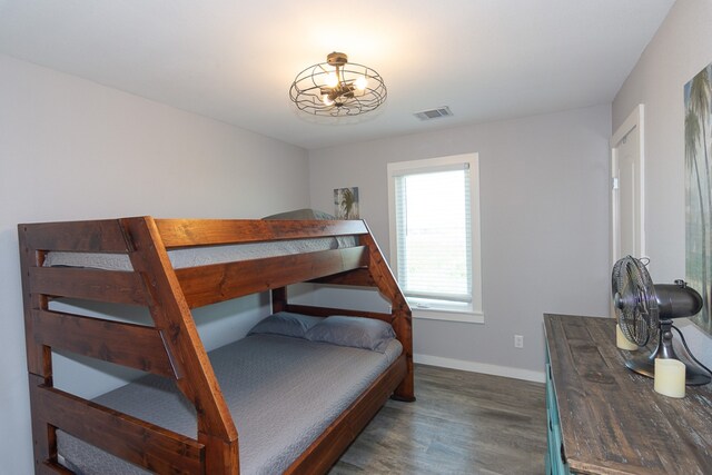 bedroom featuring wood finished floors, visible vents, and baseboards