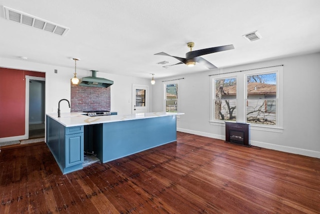 2702 S 2nd St Unit 1 & 2, Austin, TX 78704 - kitchen with blue cabinets, wall chimney exhaust hood, light countertops, and healthy amount of natural light