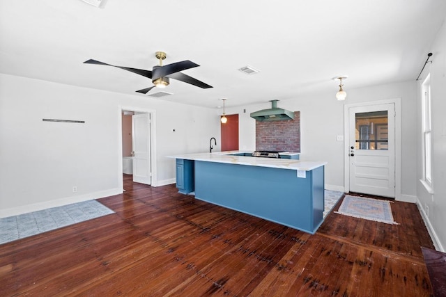 2702 S 2nd St Unit 1 & 2, Austin, TX 78704 - kitchen with blue cabinets, light countertops, wall chimney range hood, pendant lighting, and a spacious island