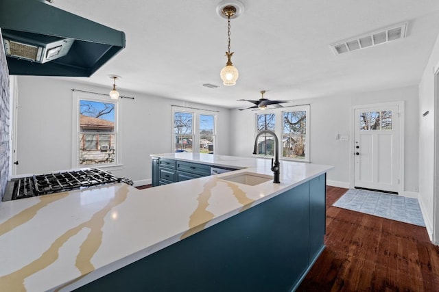 2702 S 2nd St Unit 1 & 2, Austin, TX 78704 - kitchen with extractor fan, dark wood-style floors, blue cabinets, hanging light fixtures, and light countertops