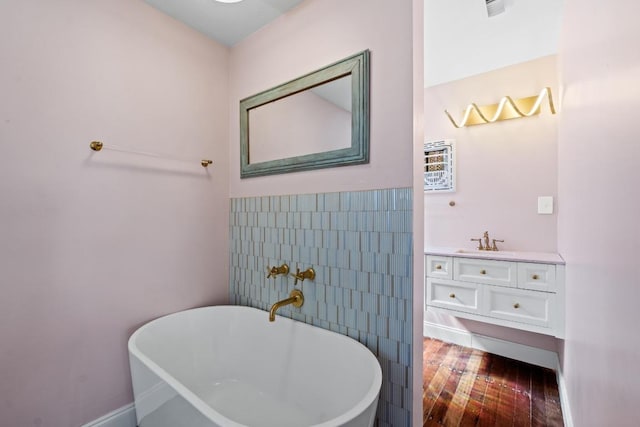 2702 S 2nd St Unit 1 & 2, Austin, TX 78704 - bathroom with tile walls, vanity, a freestanding tub, wood finished floors, and wainscoting