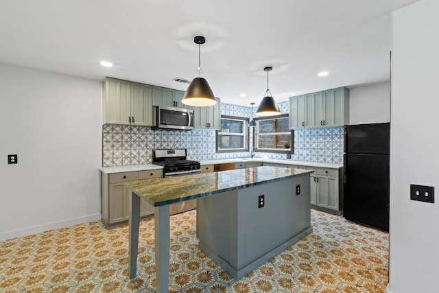2702 S 2nd St Unit 1 & 2, Austin, TX 78704 - kitchen featuring appliances with stainless steel finishes, backsplash, a center island, decorative light fixtures, and stone countertops