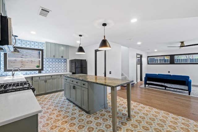 2702 S 2nd St Unit 1 & 2, Austin, TX 78704 - kitchen featuring gray cabinets, freestanding refrigerator, stainless steel range with gas cooktop, open floor plan, and tasteful backsplash