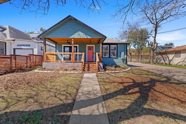 bungalow-style home with covered porch and fence