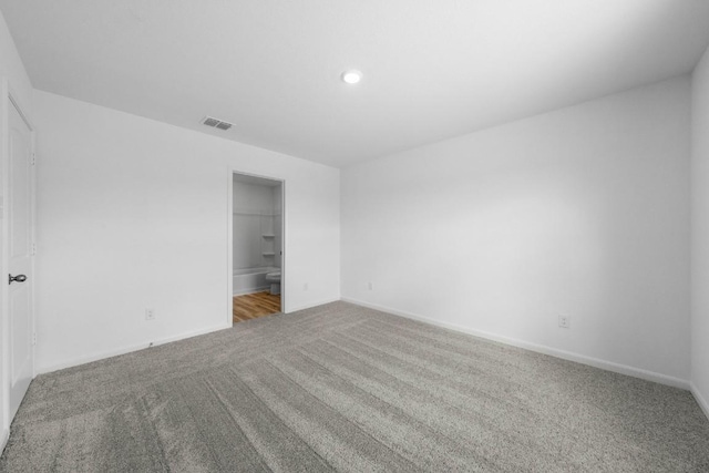 unfurnished bedroom with carpet floors, visible vents, and baseboards